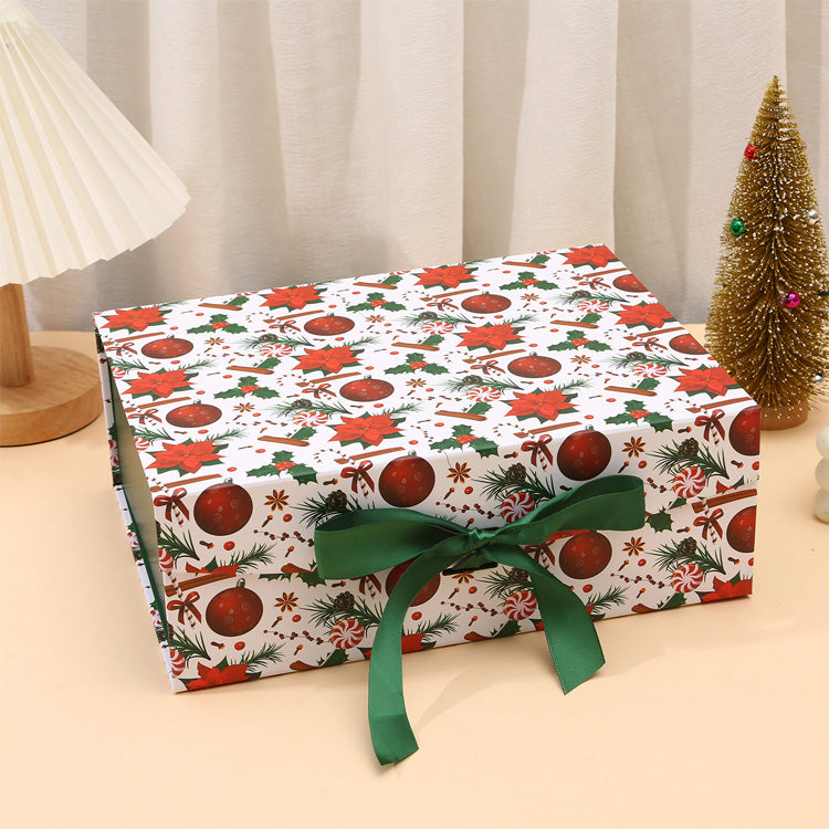 Gift box wrapped in festive paper with a green ribbon on a neutral background
